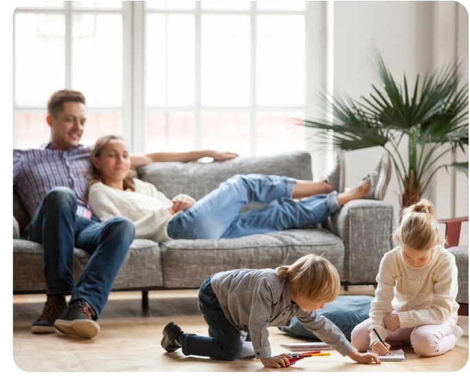 A family sitting on the floor in front of a couch