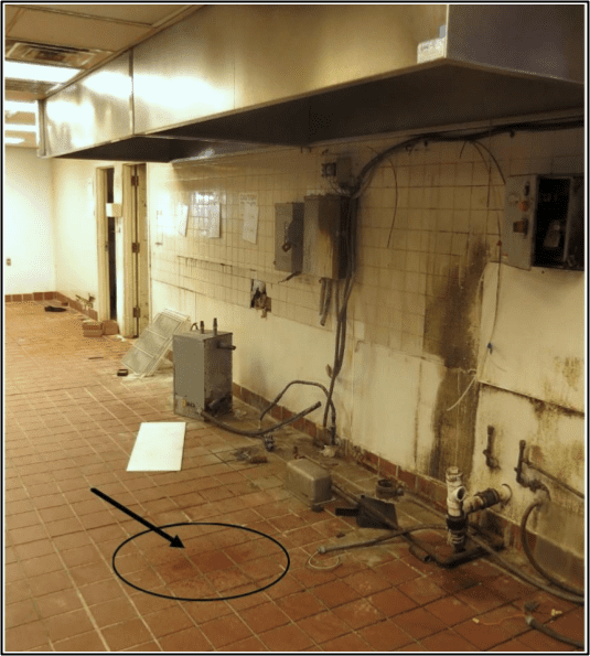 A kitchen with dirty walls and floors